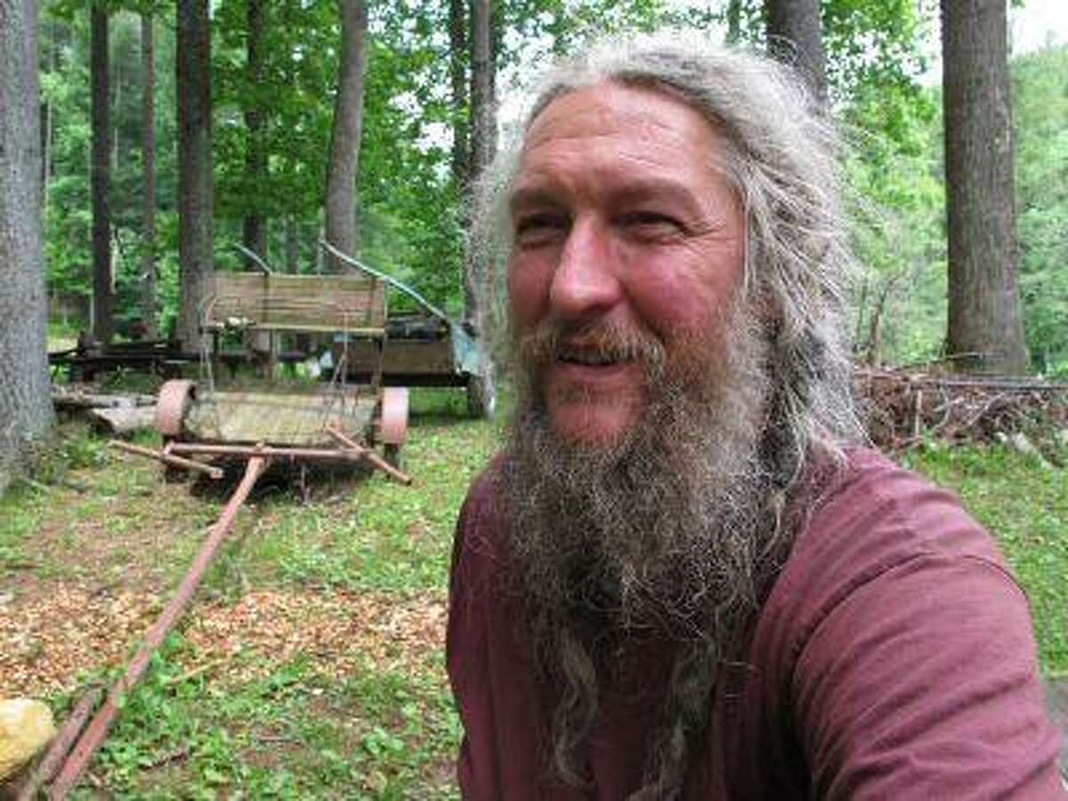Eustace Conway sits near horse-drawn farm implements at his Turtle Island Preserve in Triplett, N.C., on Thursday, June 27, 2013. People come from all over the world to learn natural living and how to go off-grid, but local officials ordered the place closed over health and safety concerns.