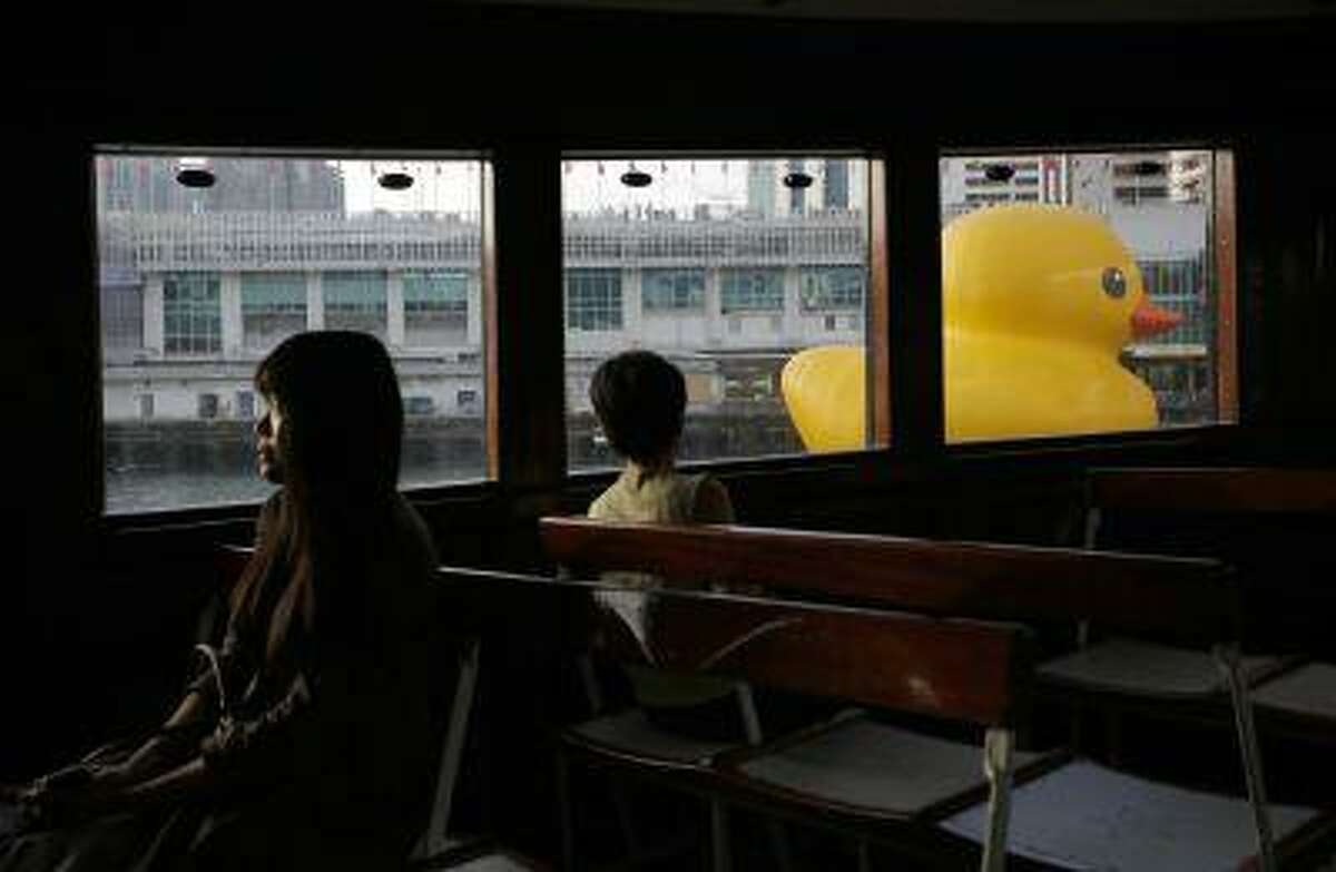 A giant rubber duck created by Dutch artist Florentijn Hofman is seen from the window of a star ferry along Hong Kong's Victoria Habour Wednesday, May 29, 2013. Since 2007 the 16.5-meter (54 feet)-tall Rubber Duck has traveled to various cites including Osaka, Sydney, Sao Paulo and Amsterdam. (AP Photo/Vincent Yu)