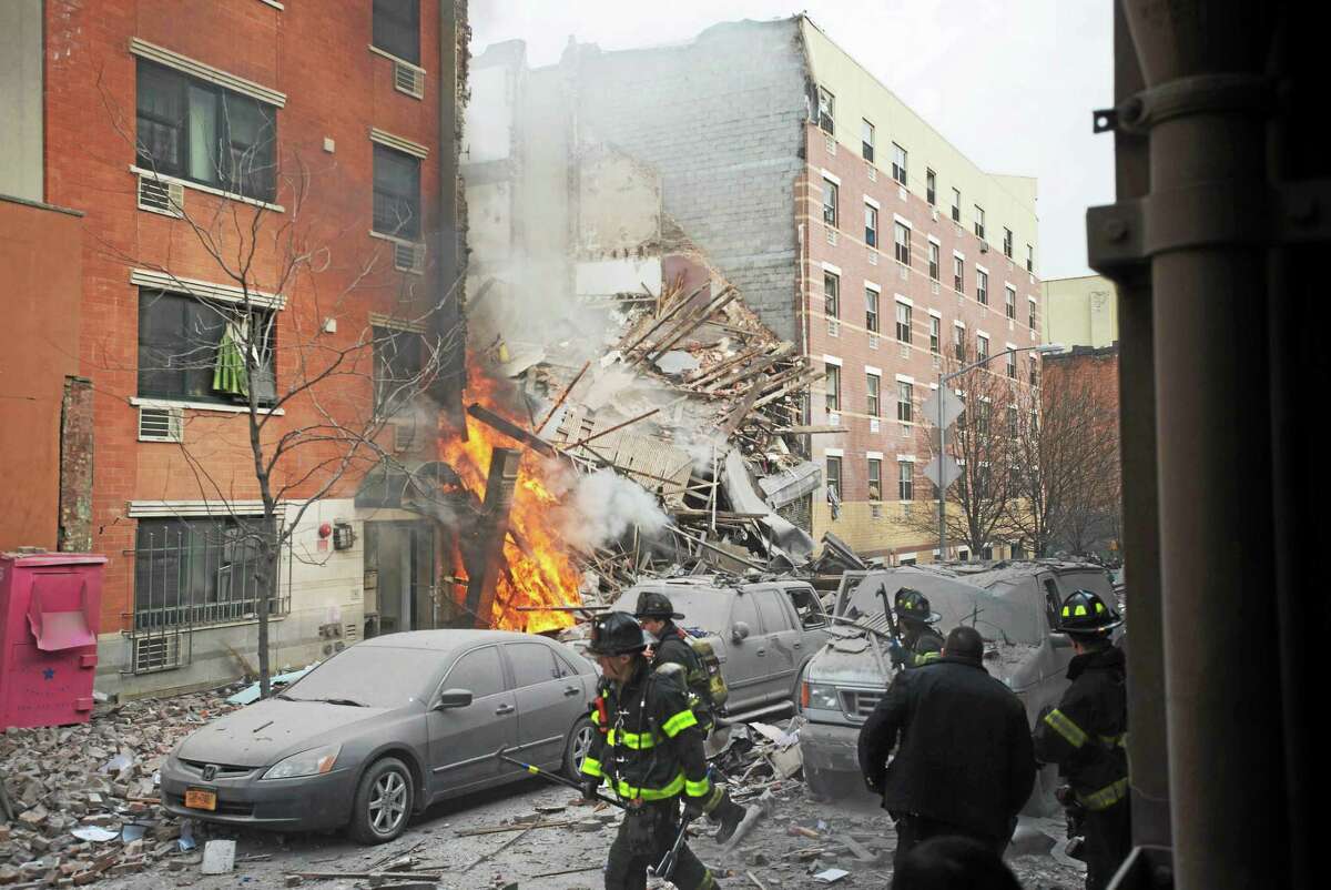 Firefighters work the scene of an explosion and building collapse in the East Harlem neighborhood of New York Wednesday. The explosion leveled two apartment buildings and sent flames and billowing black smoke above the skyline.