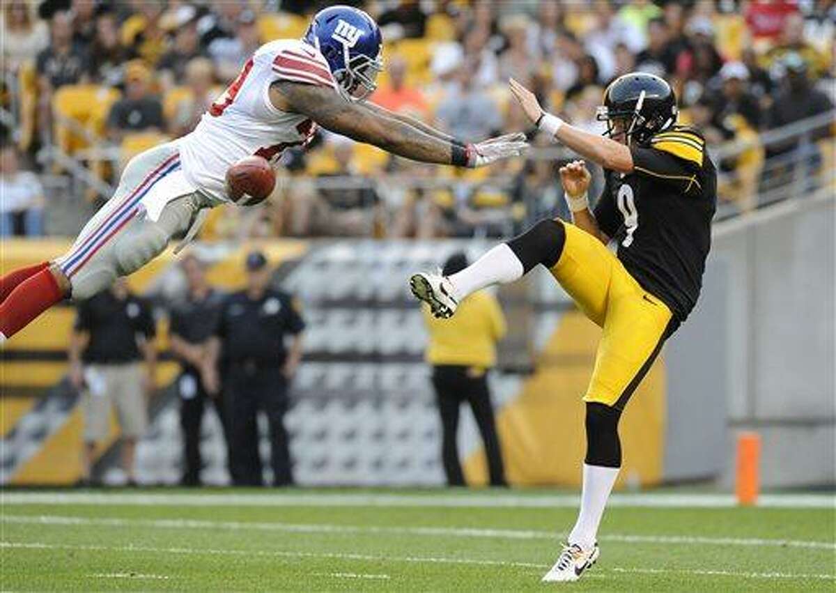 New York Giants' Damontre Moore, left, blocks a punt by Pittsburgh Steelers punter Drew Butler (9) in the first quarter of an NFL preseason football game Saturday, Aug. 10, 2013, in Pittsburgh. (AP Photo/Don Wright)