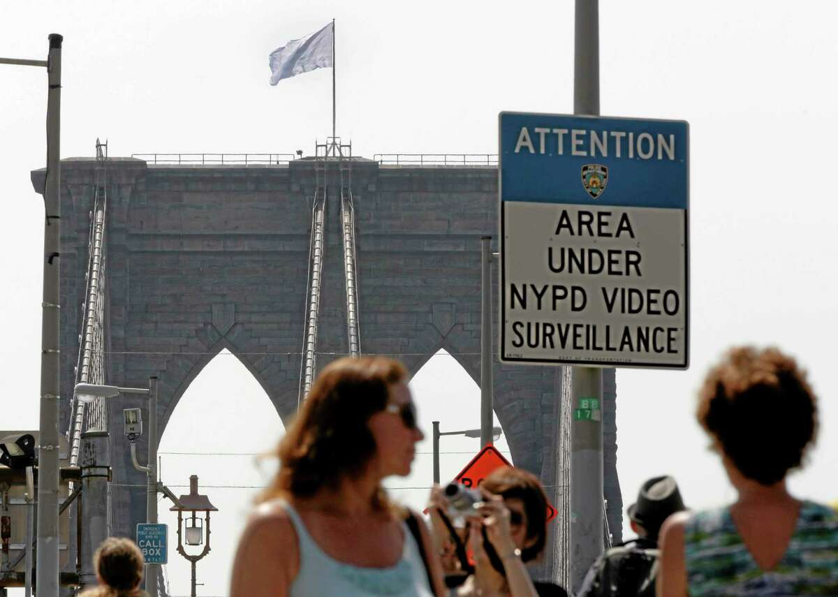 A white flag flies atop the west tower of New York's Brooklyn Bridge, Tuesday, July 22, 2014. Two large American flags atop the Brooklyn Bridge were replaced sometime during the night with white banners. Police crime scene and intelligence detectives were investigating how the flags were switched out on the famed span that connects Brooklyn and Manhattan, and there were no reports of suspicious activity, police said. (AP Photo/Richard Drew)
