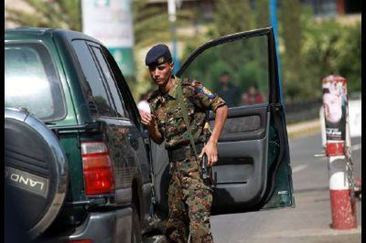 A police trooper inspects a vehicle at the entrance of the Sanaa International Airport on August 7, 2013.