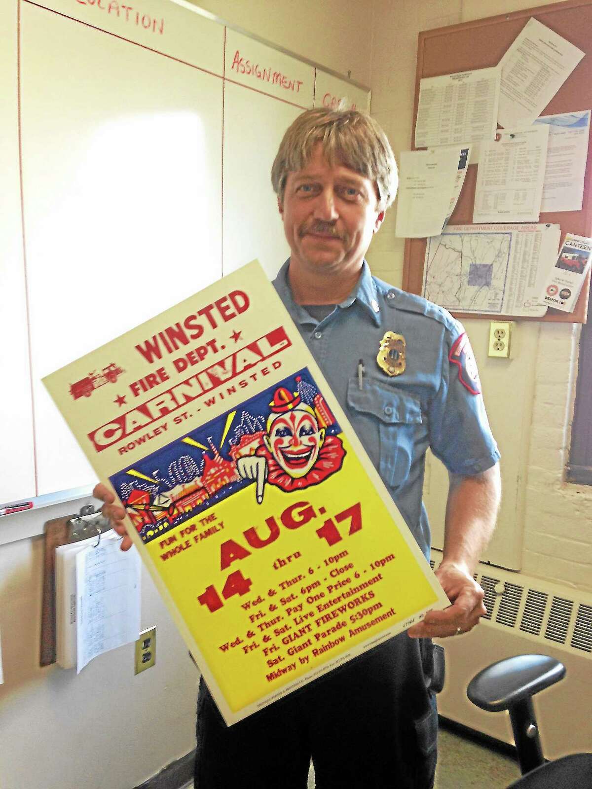 Capt. James Lagassie holds a flier for the Winsted Fire Department’s upcoming carnival.