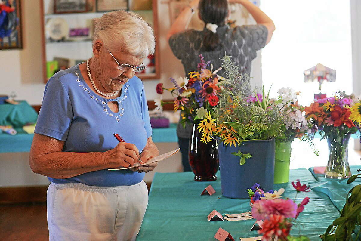 Submitted photo - Riverton Grange The Riverton Grange Fair is Aug. 16, and features entries of flowers, baked goods, photographs and more. Above, a judge picks her favorites during the 2013 fair.