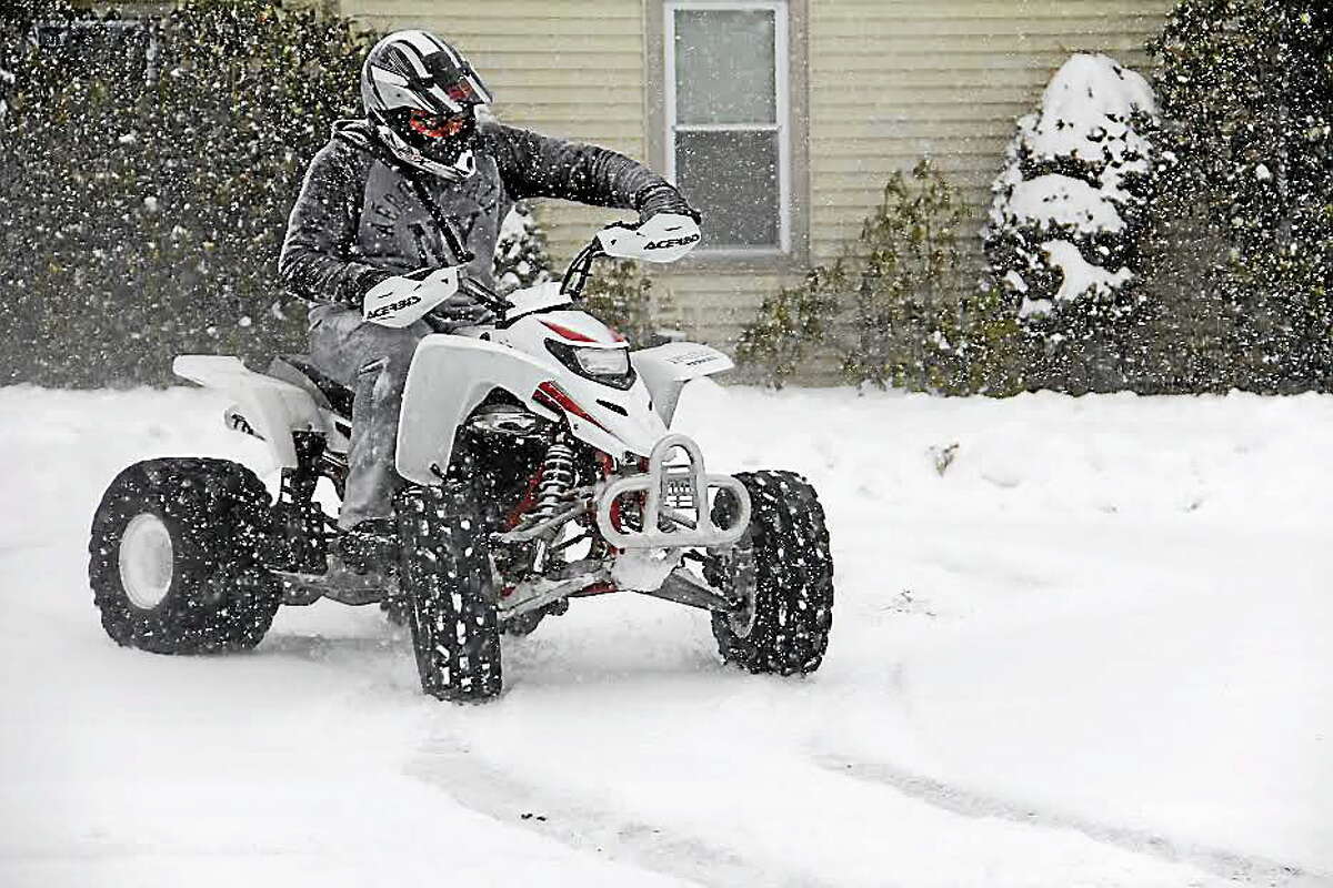 John Muniz, a freshman at Torrington High School, enjoys his snow day with an ATV ride on Tuesday, Dec. 17, 2013, in Torrington. THS was one of several schools in the area who closed on Tuesday as several inches of snow blanketed Litchfield County.