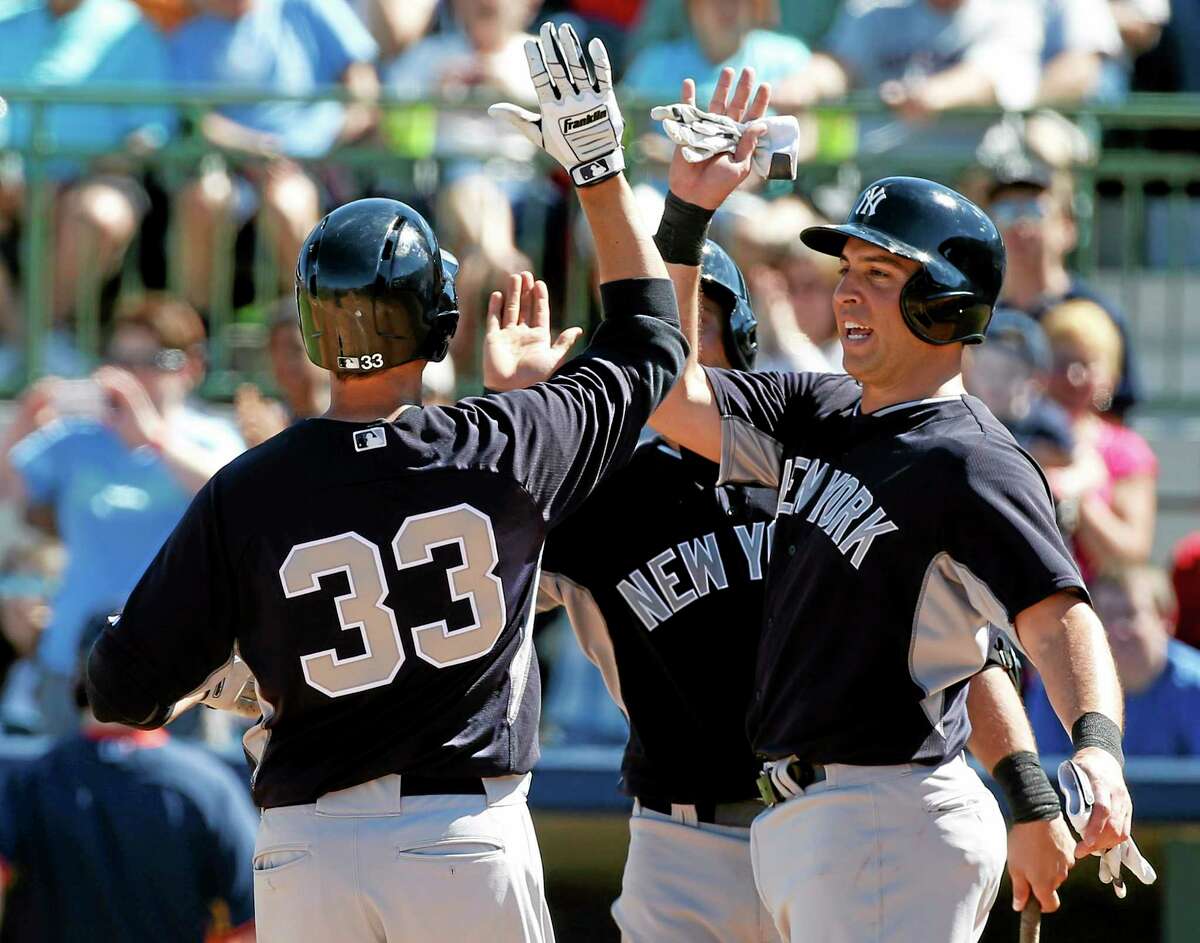New York Yankees' Kelly Johnson (33) and Mark Teixeira (25) celebrate Johnson's two-run home run in the third inning of a exhibition baseball game against the Houston Astros, Saturday, March 8, 2014, in Kissimmee, Fla. (AP Photo/Alex Brandon)
