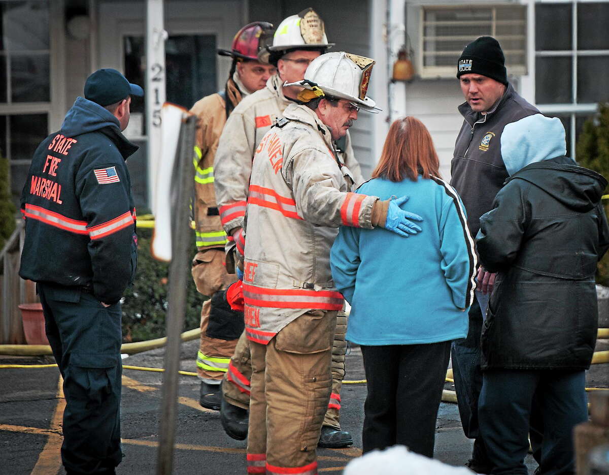 Fire Chief James O’Brien talks with a woman at the scene of a triple-fatal fire in West Haven on Tuesday.