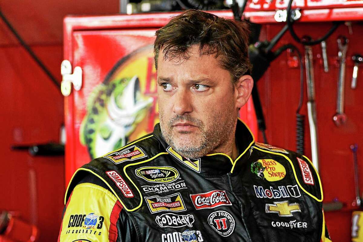 In this Aug. 8, 2014 photograph, Tony Stewart stands in the garage area after a practice session for Sunday’s NASCAR Sprint Cup Series auto race at Watkins Glen International, in Watkins Glen N.Y.
