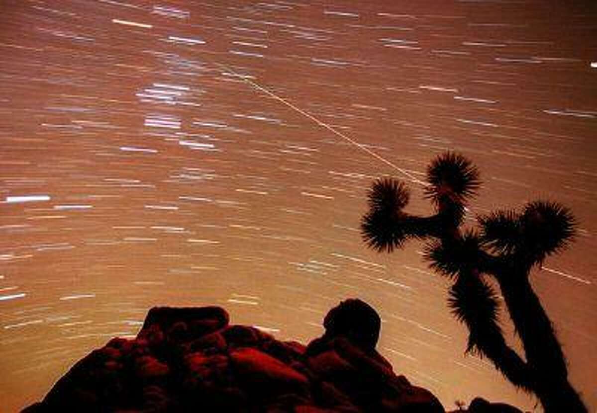 A meteor streaks through the sky over Joshua trees and rocks at Joshua Tree National Park in Southern California's Mojave Desert in this 30-minute time exposure ending at 1:15 a.m. PST Tuesday, Nov. 17, 1998.