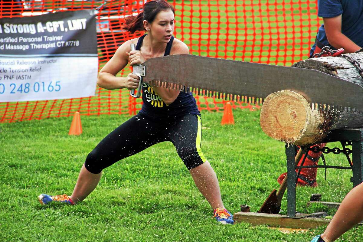 Kimi Sekorski saws through a large piece of wood with the help of a partner during a wood chopping demonstration at Bantam Community Day on Saturday, August 9, in Bantam. Esteban L. Hernandez Register Citizen