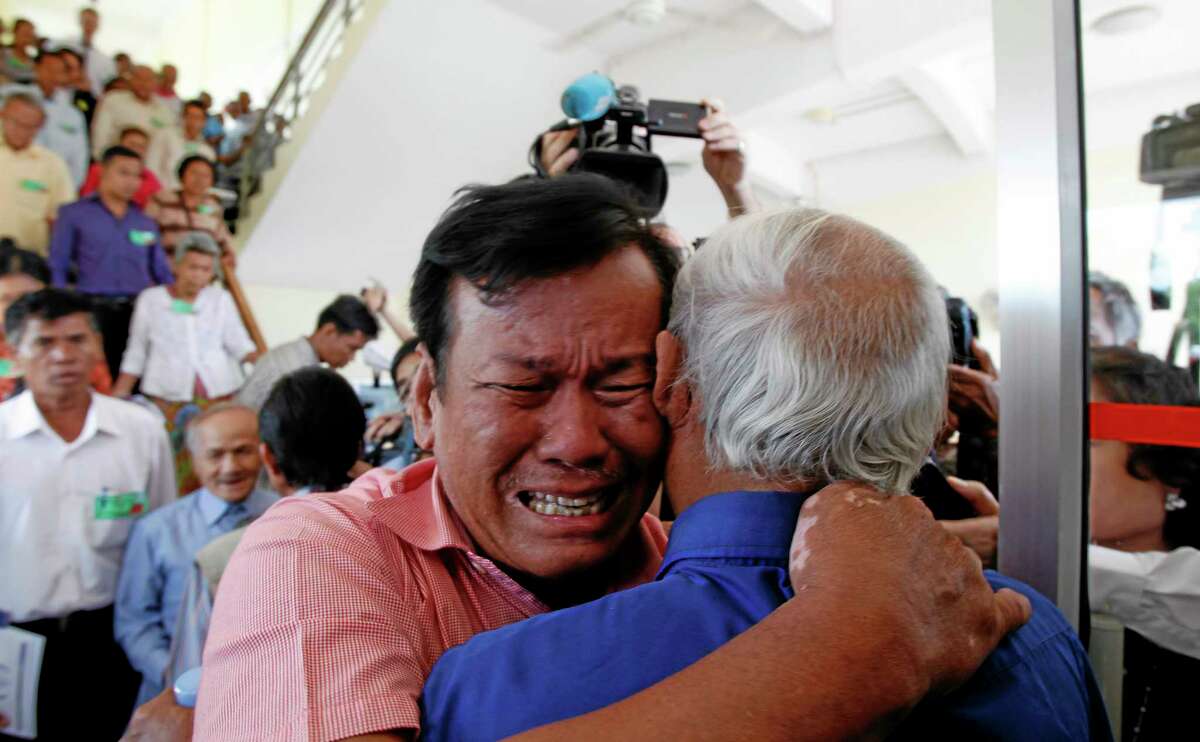 Cambodian former Khmer Rouge survivors, Soum Rithy, left, and Chum Mey, right, embrace each other after the verdicts were announced, at the U.N.-backed war crimes tribunal in Phnom Penh, Cambodia, Thursday, Aug. 7, 2014. Three and a half decades after the genocidal rule of Cambodia's Khmer Rouge ended, the tribunal on Thursday sentenced two top leaders of the former regime to life in prison on war crimes charges for their roles during the country's 1970s terror. (AP Photo/Heng Sinith)