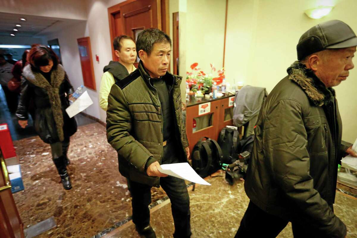 Chinese relatives of passengers aboard a missing Malaysia Airlines plane are leaving a hotel for relatives or friends of passengers aboard the missing airplane to apply for a passport in Beijing, China Sunday, March 9, 2014. Planes and ships from across Asia resumed the hunt Sunday for a Malaysian jetliner missing with 239 people on board for more than 24 hours, while Malaysian aviation authorities investigated how two passengers were apparently able to get on the aircraft using stolen passports. (AP Photo/Vincent Thian)