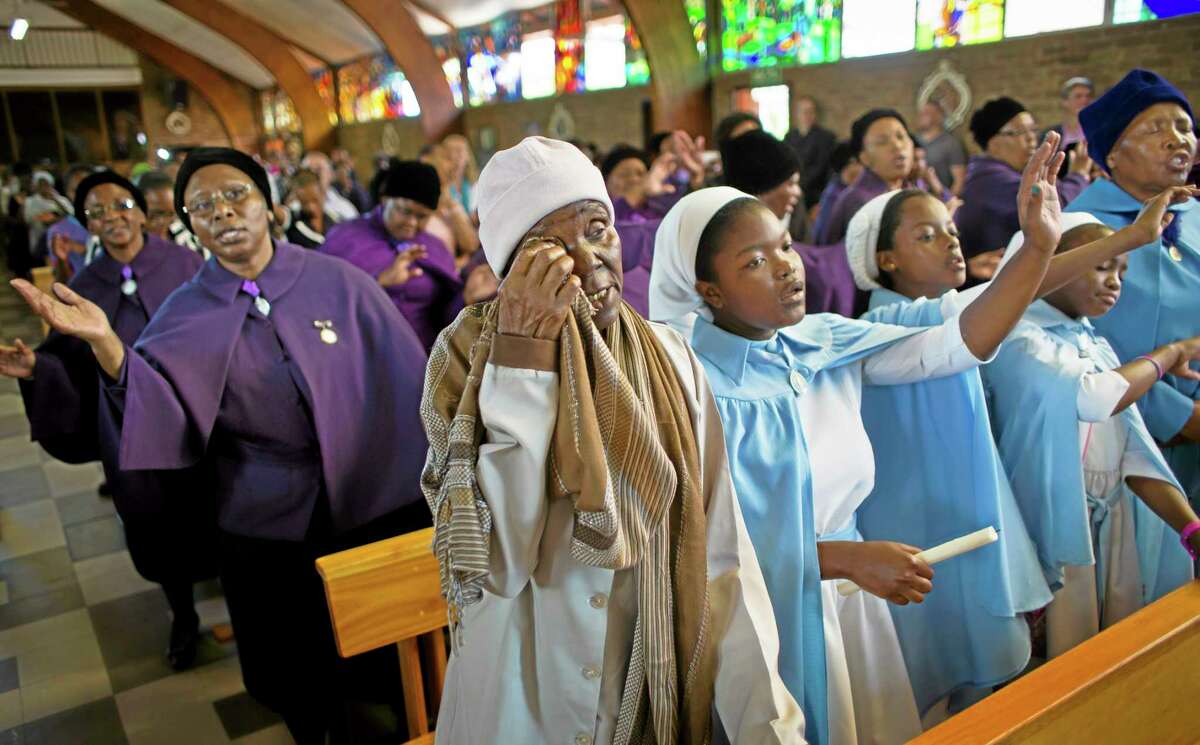 A mourner wipes away a tear at a morning mass in memory of Nelson Mandela at the Regina Mundi church, which became one of the focal points of the anti-apartheid struggle, in Soweto, Johannesburg, South Africa Sunday, Dec. 8, 2013. South Africans flocked to houses of worship Sunday for a national day of prayer and reflection to honor Nelson Mandela, starting planned events that will culminate in what is expected to be one of the biggest funerals in modern times. (AP Photo/Ben Curtis)