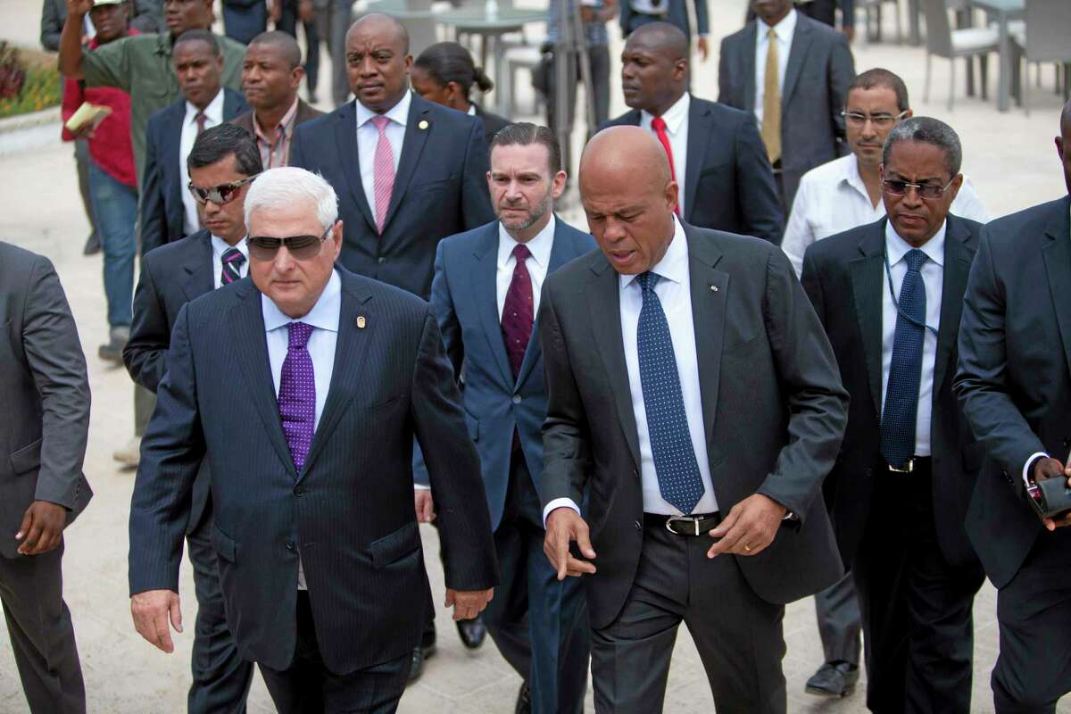 Haitian president Michel Martelly, right, walks with Panama's President Ricardo Martinelli, left, after a joint press conference in Petion-Ville, Haiti, Wednesday Feb. 19, 2014. Panamanian President Ricardo Martinelli arrived in Haiti as part of an effort to promote business between the two countries that have not traditionally had strong ties. (AP Photo/Dieu Nalio Chery)