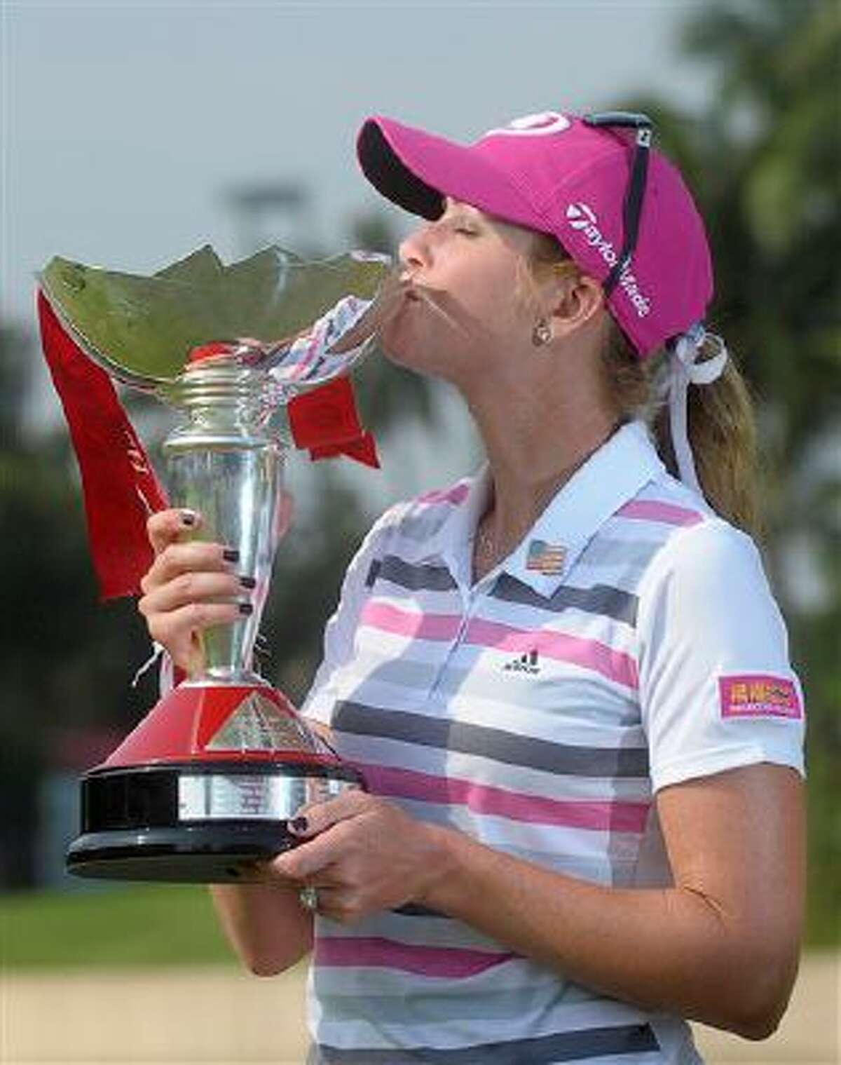 Paula Creamer of the U.S. kisses her champion trophy during the award ceremony of the HSBC Women's Champions golf tournament in Singapore, Sunday, Mar. 2, 2014. (AP Photo/Joseph Nair)
