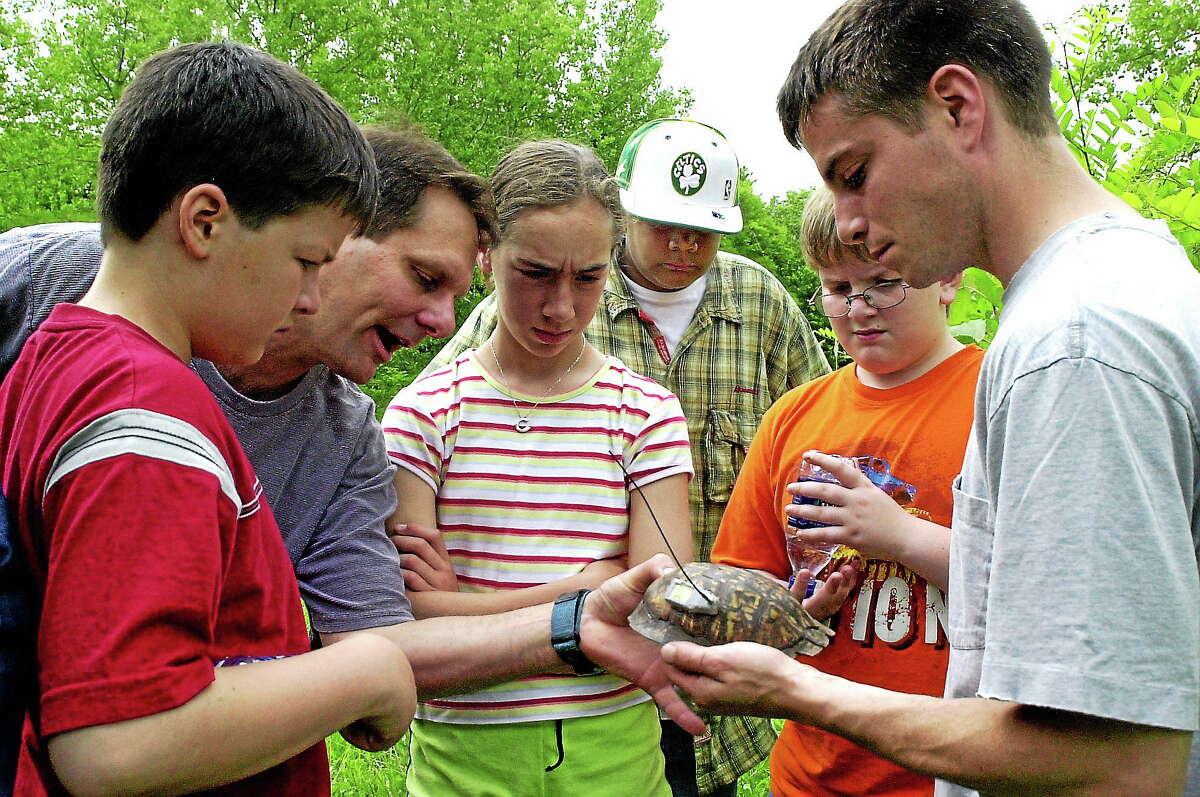Dennis Quinn, right, shows a turtle shell during a Connecticut BioBlitz at the CREC Two Rivers Magnet School in East Hartford.