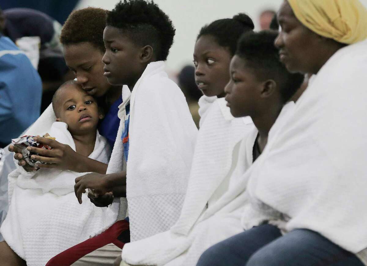 Terranysha Ferguson holds her son, Christian Phillips, 1, as she sits with the rest of her family at the convention center.
