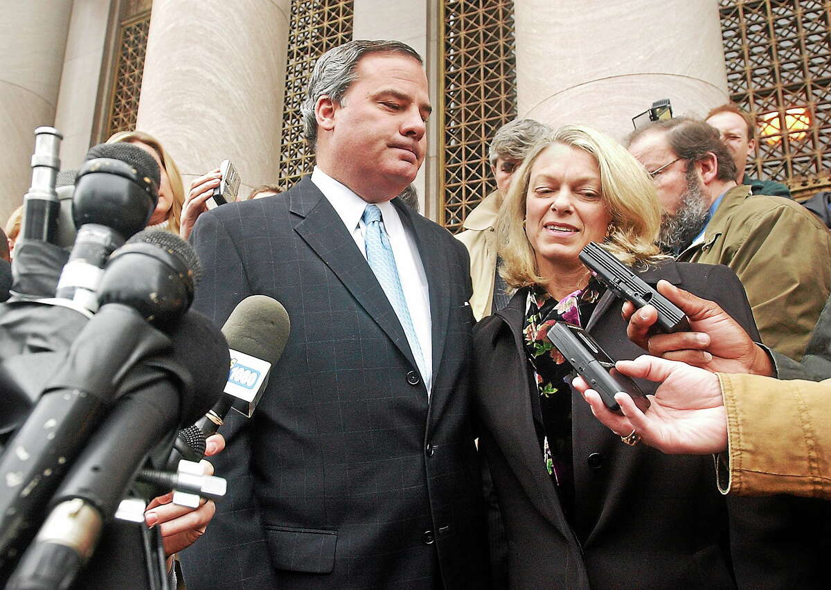 Former Gov. John G. Rowland speaks with members of the press outside court after pleading guilty to the federal charge of conspiracy to steal honest services Dec. 23. 2004. At right is his wife, PatriciaD.