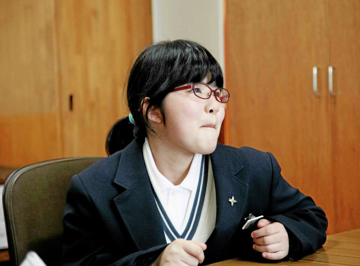 In this Saturday, April 5, 2014 photo, Kokoro Kamiyama, 13, who started her new life after moving from Fukushima, smiles during an interview in Matsumoto, central Japan. Kamiyama is the first child to sign on to the Matsumoto project which Chernobyl-doctor-turned-mayor Akira Sugenoya of Matsumoto offered his Japanese town to get children out of Fukushima. Kamiyama was prone to skipping school when she was in Fukushima, which her mother believes was a sign of stress from worrying about radiation. She is happy she can run around outdoors in the city without wearing a mask. ìThe air feels so clean here,î Kamiyama said. ìI love playing badminton. And tag.î (AP Photo/Koji Sasahara)