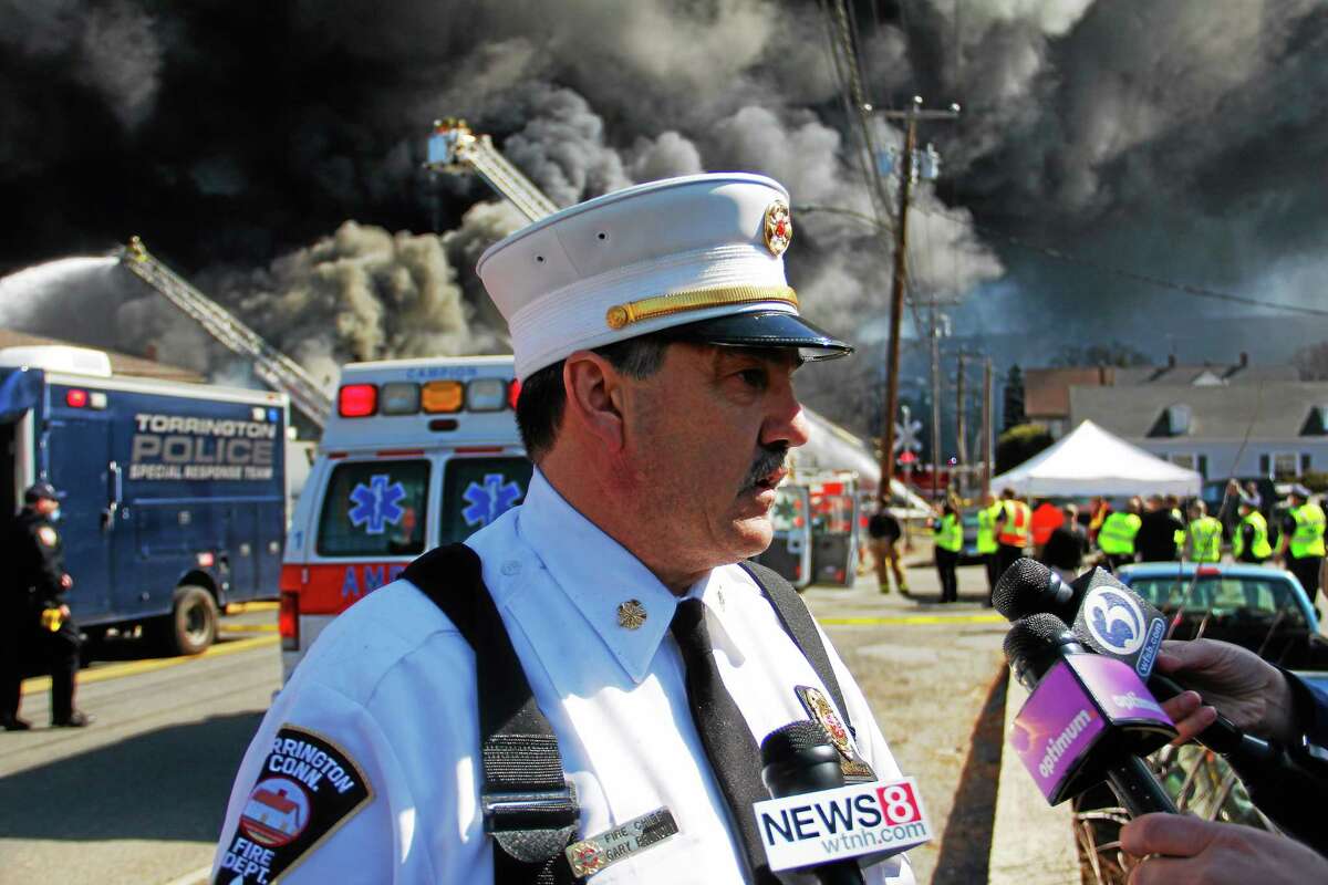 Chief Gary Brunoli talks with reporters as Torrington and dozens of other departments battle a five-alarm blaze at Toce Brothers Inc., a warehouse full of tires, on Albert St in Torrington.