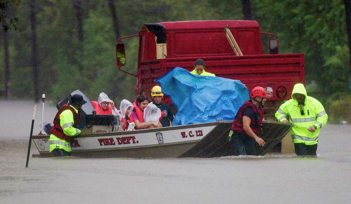 Porter fire fighters evacuate a family by boat from a neighborhood off East Knox Drive, Sunday, Aug. 27, 2017, in Porter.