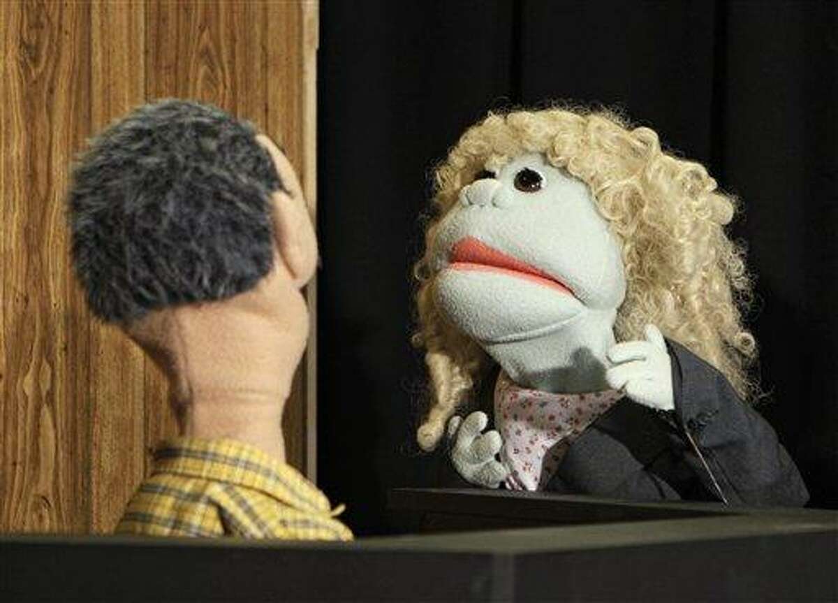 A puppet representing defense attorney Andrea Whitaker cross-examines a Ferris Kleem puppet during taping at WOIO-TV in Cleveland Thursday, Jan. 19, 2012. The station uses the puppets performing as witnesses, reporters and jurors to detail the corruption trial against former Cuyahoga county commissioner Jimmy Dimora, which began last week in federal court in Akron. (AP Photo/Mark Duncan)