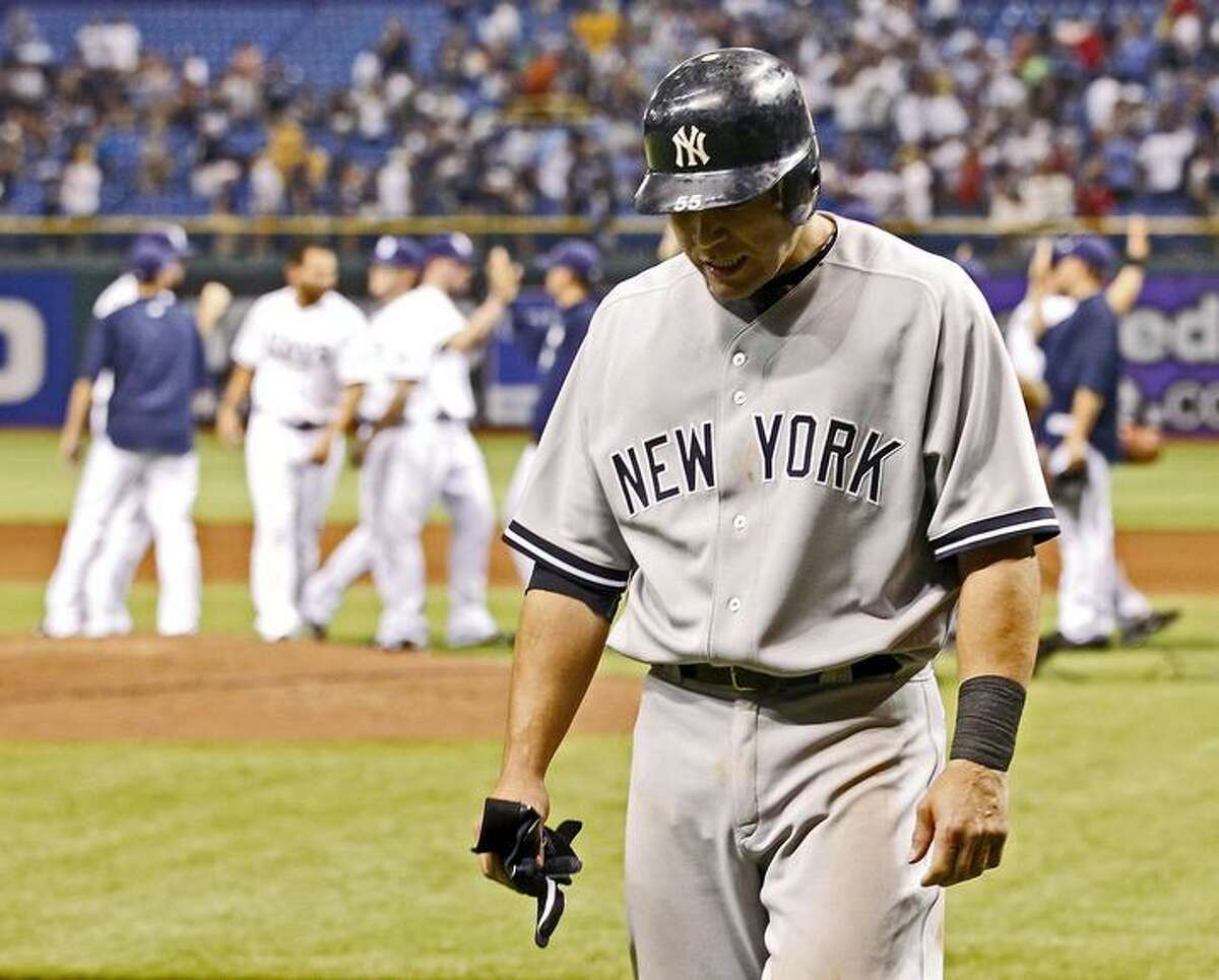 New York Yankees' Russell Martin walks back to the dugout at the end of the game as the Tampa Bay Rays celebrate their 6-5 win in a baseball game Monday, May 16, 2011, in St. Petersburg, Fla. (AP Photo/Mike Carlson)