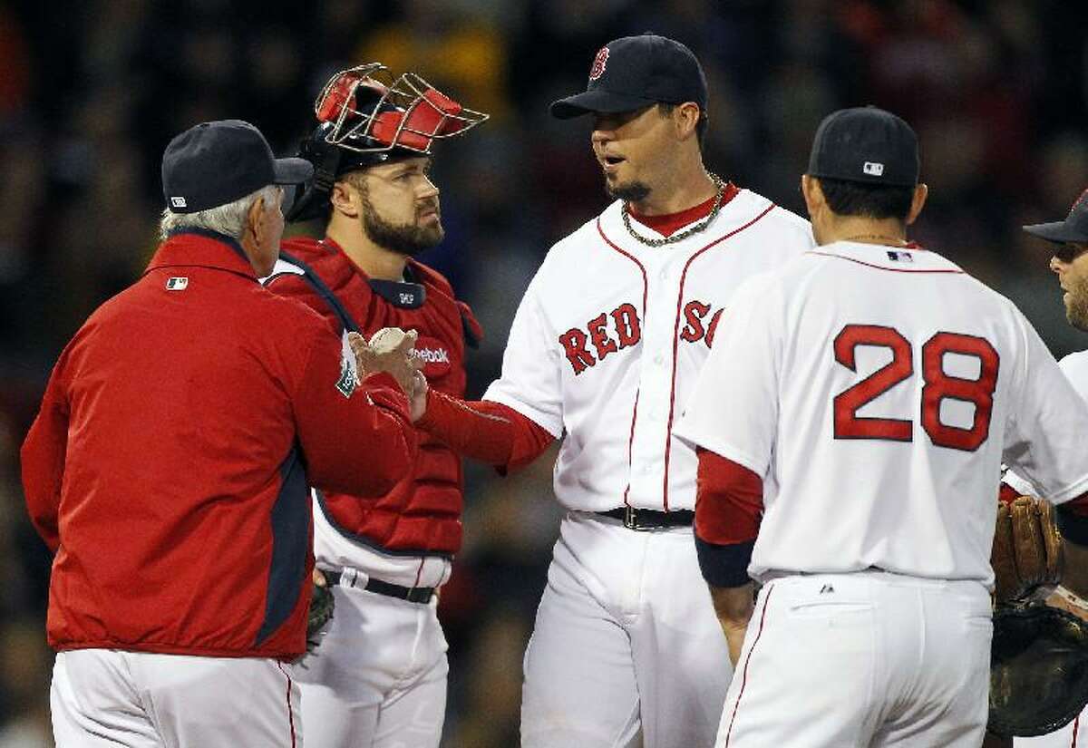 ASSOCIATED PRESS Boston Red Sox pitcher Josh Beckett, second from right, hands the ball to manager Bobby Valentine, left, and leaves the game as catcher Kelly Shoppach, second from left, and Adrian Gonzalez (28) watch in the third inning of Thursday's game against the Cleveland Indians at Fenway Park in Boston.