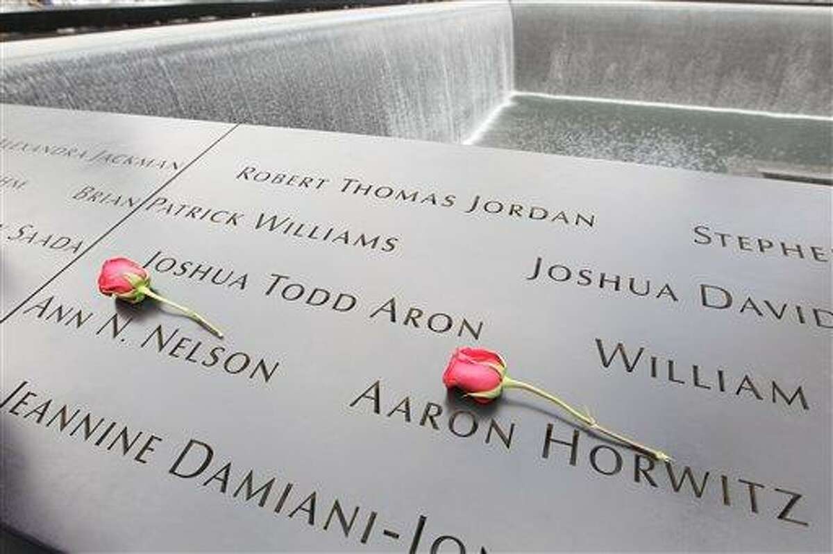 Roses lay on the north pool placed by Dawn Nelson in memory of her sister Ann N. Nelson and Aaron Horwitz at the National September 11 Memorial during a ceremony marking the 10th anniversary of the attacks at World Trade Center, Sunday, Sept. 11, 2011 in New York. (AP Photo/Mary Altaffer)