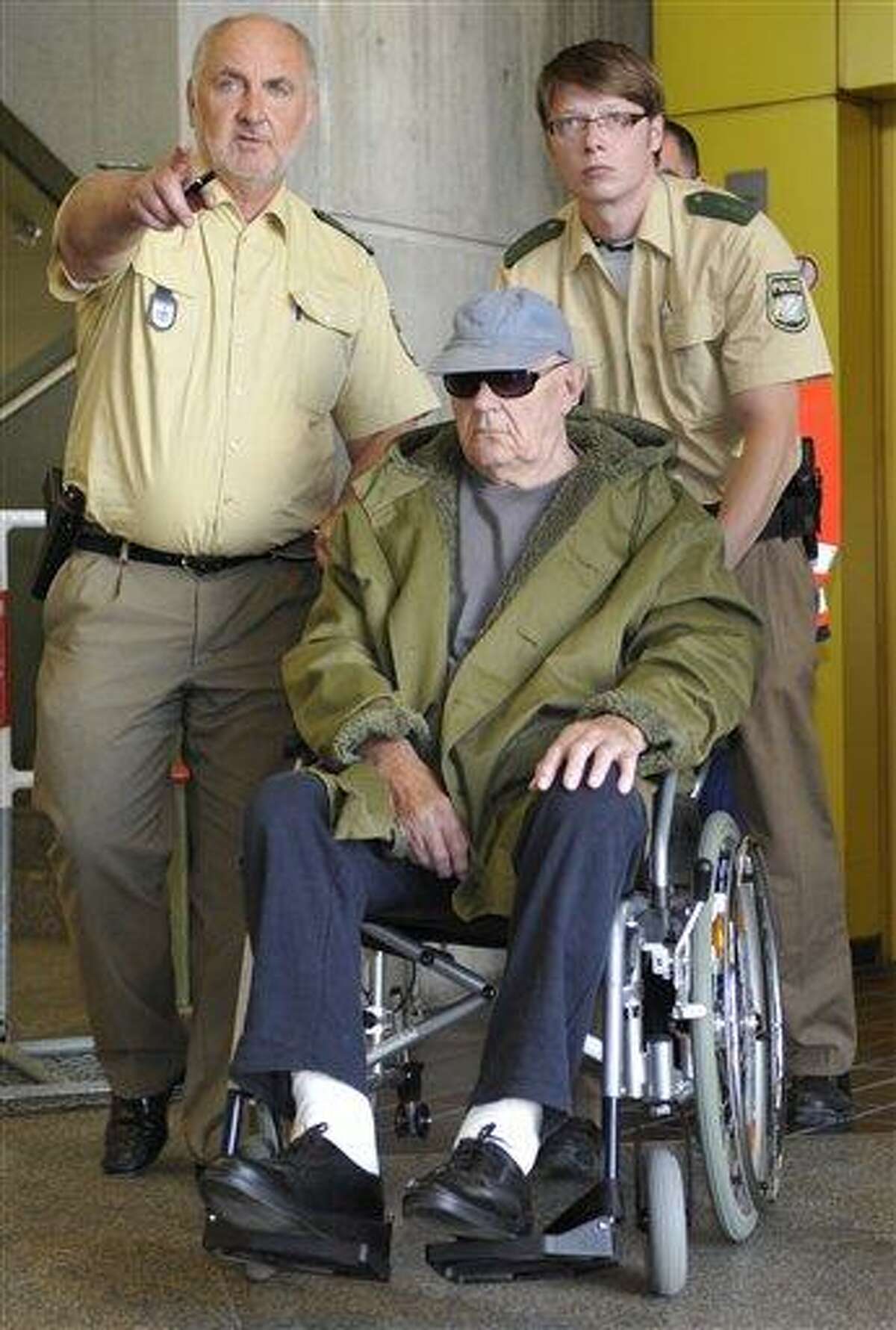 John Demjanjuk arrives in his wheelchair at the court building in Munich, southern Germany, on Tuesday, May 10, 2011. Ukrainian-born Demjanjuk, 90, is accused of 28,060 counts of accessory to murder for allegedly serving as a guard in the Nazis' Sobibor death camp. John Demjanjuk's attorney argued Tuesday that the German trial against his client lacks a legal basis because the Sobibor camp lies in neighboring Poland. (AP Photo/dapd, Uwe Lein)