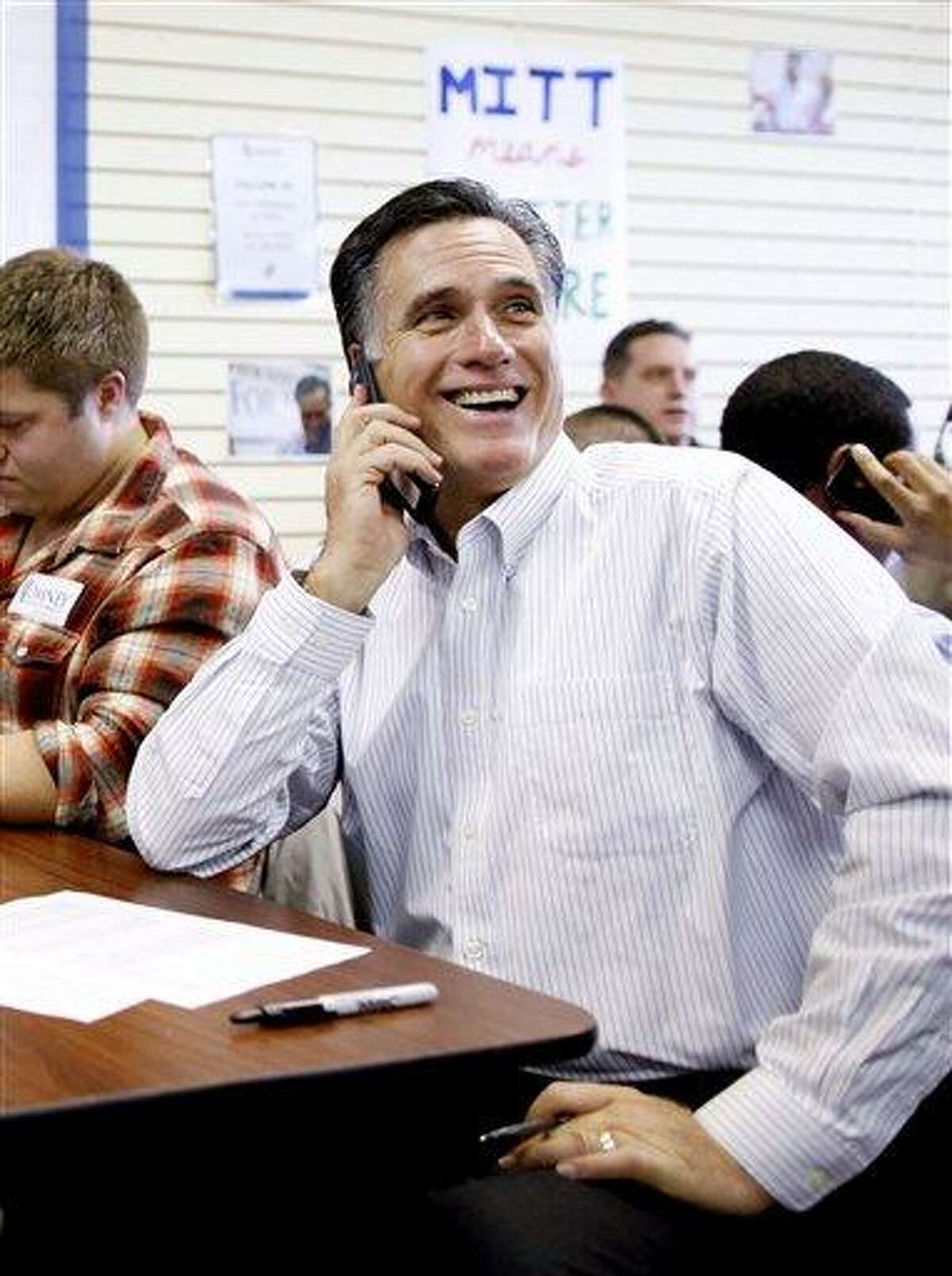 Republican presidential candidate and former Massachusetts Gov. Mitt Romney sits with volunteers and calls likely voters ahead of Tuesday's primary election in Manchester, N.H. Associated Press
