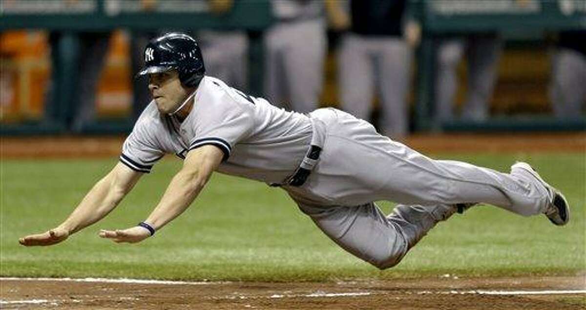 New York Yankees' Steve Pearce dives towards home plate scoring on a fielder's choice by teammate Derek Jeter and an error by Tampa Bay Rays second baseman Elliot Johnson during the seventh inning of a baseball game, Wednesday, Sept. 5, 2012, in St. Petersburg, Fla. (AP Photo/Chris O'Meara)