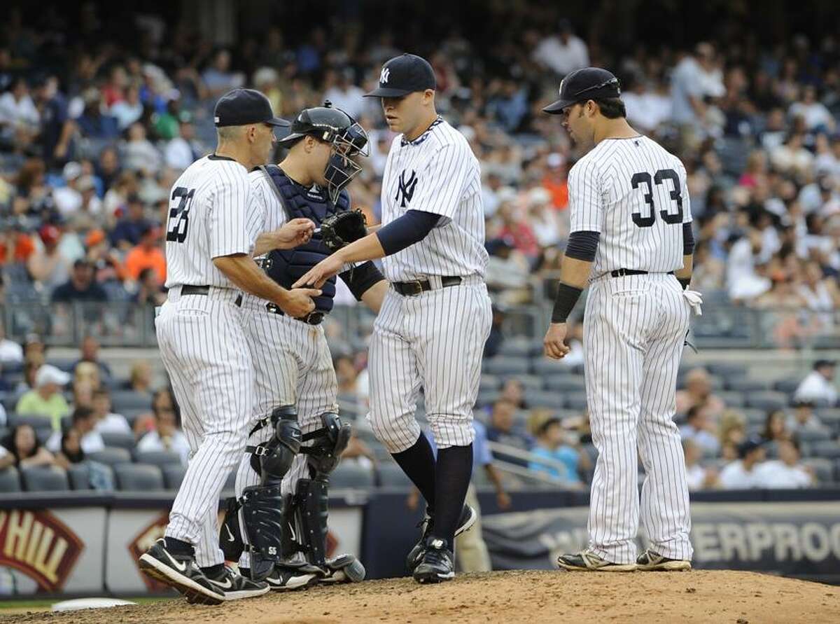 New York Yankees catcher Russell Martin, second from left, and Nick Swisher (33) watch manager Joe Girardi take Justin Thomas out against the Baltimore Orioles in the eighth inning of a baseball game on Sunday, Sept. 2, 2012, at Yankee Stadium in New York. The Orioles won 8-3. (AP Photo/Kathy Kmonicek)