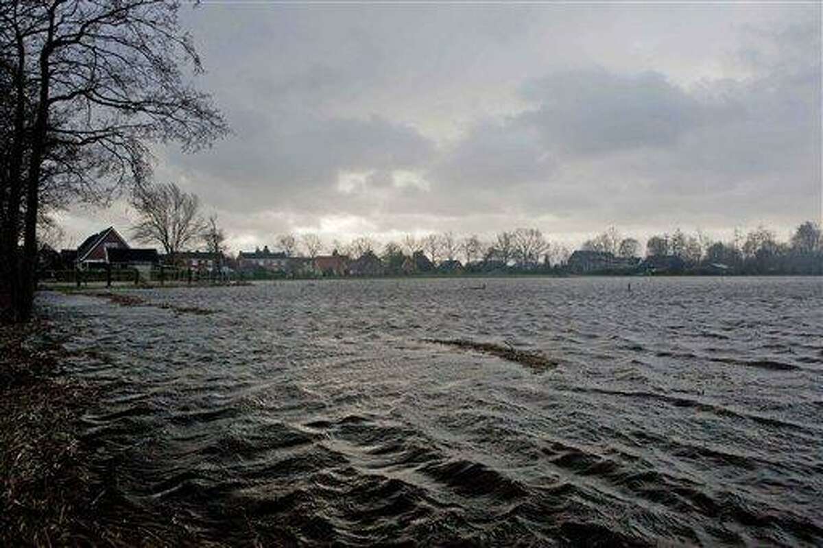 Farm land is inundated by flood water around the village of Boerakker, rear, northern Netherlands, Thursday. Farmers were told to evacuate a village in the Netherlands' low-lying north after days of driving rain and strong winds sparked fears of a dike breach. Authorities also cordoned off river banks in some areas of the densely populated south, distributing sandbags in flood-prone regions as the Netherlands resumed its never-ending battle to stay dry. A quarter of the country of nearly 17 million people lies below sea level, and 55 percent is considered vulnerable to flooding, according to the nation's Environmental Assessment Agency. (AP Photo/Peter Dejong)