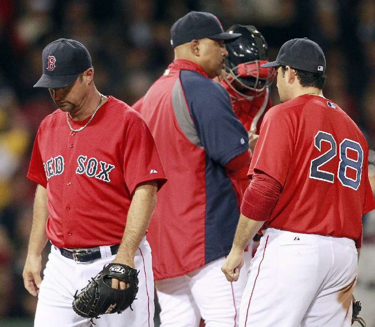 ASSOCIATED PRESS Boston Red Sox starting pitcher Tim Wakefield, left, walks back to the dugout after being taken out of the game by bench coach Demarlo Hale, center, in the fifth inning of Friday's game against the Minnesota Twins at Fenway Park in Boston. The Red Sox lost 9-2.