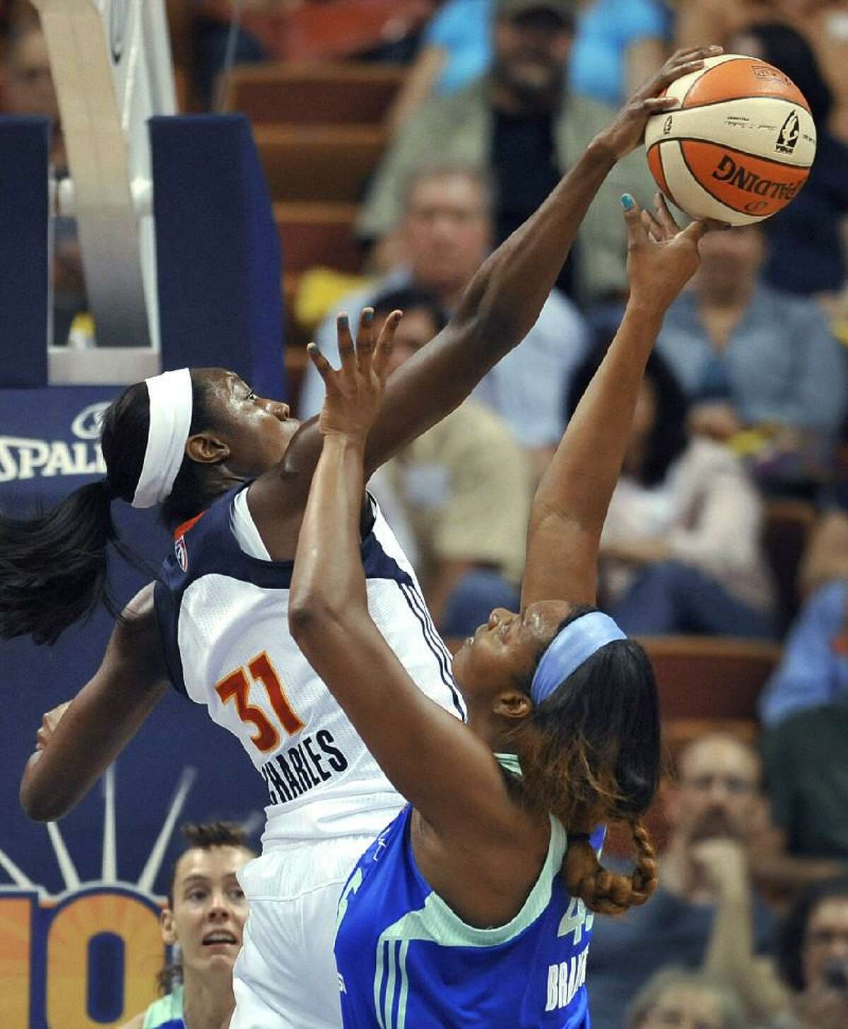 ASSOCIATED PRESS Connecticut Sun's Tina Charles, left, blocks a shot by New York Liberty's Kara Braxton in the first half of Friday's game in Uncasville. The Sun won 97-55.