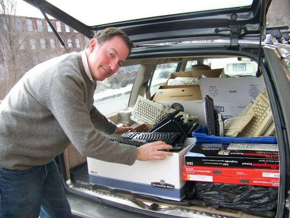 State Rep. John Rigby loads his car with donated computer keyboards, which he plans to send to troops overseas.