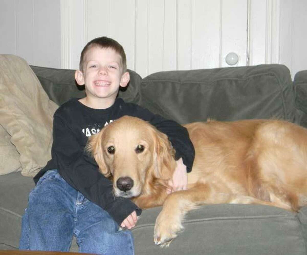 MIKE AGOGLIATI/ Register Citizen Tyler Bouteiller and his service dog Duncan pose for a picture at his house. The family is holding a benefit dinner to help raise funds to offset the cost of the service dog on March 28 at LaMonica's.