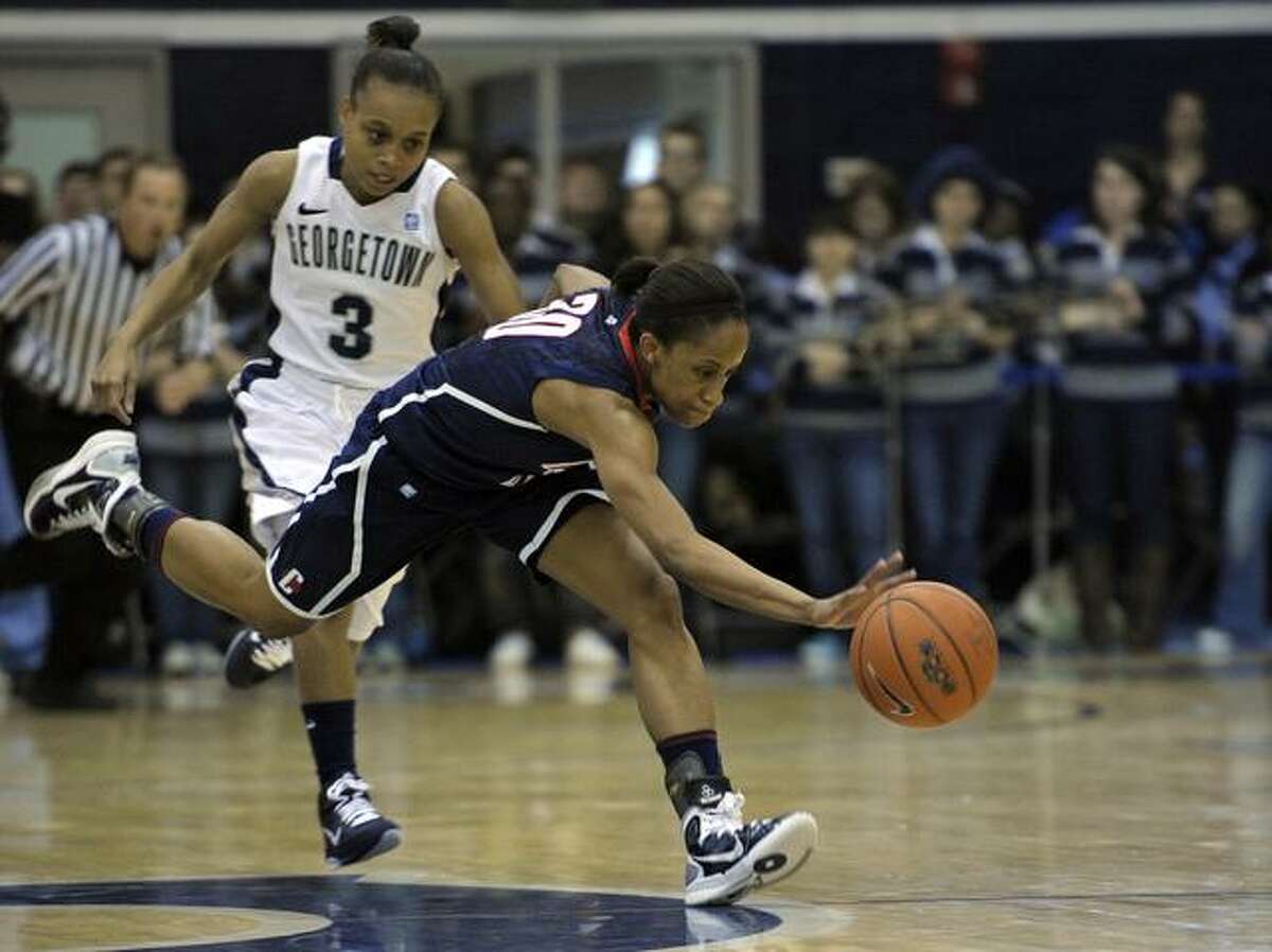 Connecticut's guard Lorin Dixon (30) scrambles for a loose balll near half-court as Georgetown guard Rubylee Wright (3) chases her during the first period of their Big East game in Washington, Saturday, Feb. 26, 2011. (AP Photo/Cliff Owen)