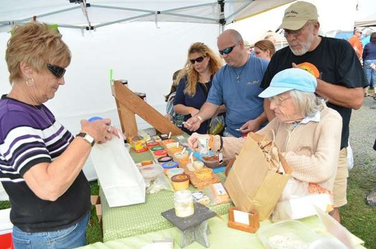 Mary Brockway of Country Pride Cheeses in Hobart, NY faces the long lines of customers sampling and buying her cheese products at the Garlic Festival on Saturday in Bethlehem. Brockway said that they have come to the Garlic Festival for the past five years and they have watched it grow each year. John Berry/Register Citizen