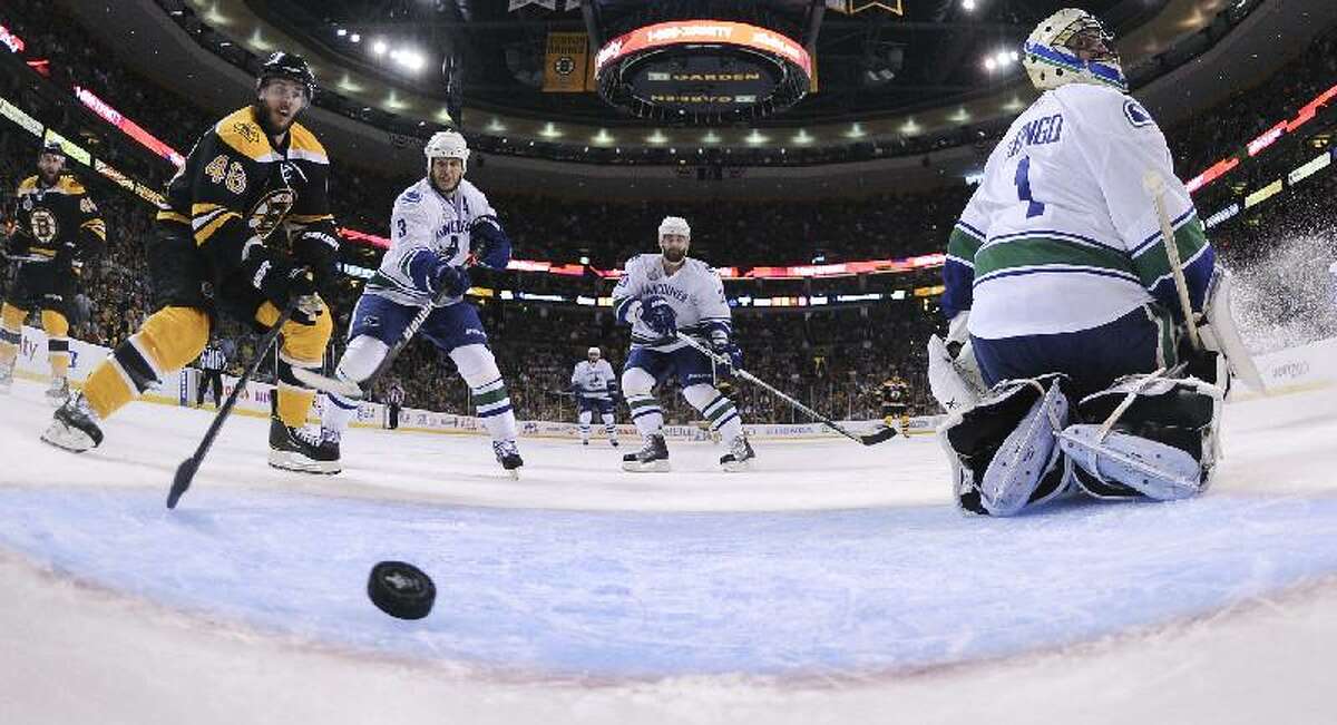 ASSOCIATED PRESS Vancouver Canucks goalie Roberto Luongo (1) looks for the puck as it crosses the goal line for the Bruins' second goal of the first period during Game 6 of the NHL hockey Stanley Cup Finals Monday in Boston. Bruins center David Krejci (46) and Vancouver's Kevin Bieksa (3) and Chris Higgins look on.