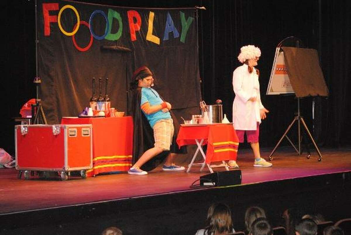 MIKE AGOGLIATI/ Register Citizen Johnny Junkfood, played by Keith Allen and Coach, played by Jenna Hoff, teach kids how soda is made during a presentation of Food play held at the Warner Theatre Monday afternoon. The show teaches kids healthy eating and exercising habits and reached more than 3,200 children in Torrington and Winchester during two shows at the theatre.