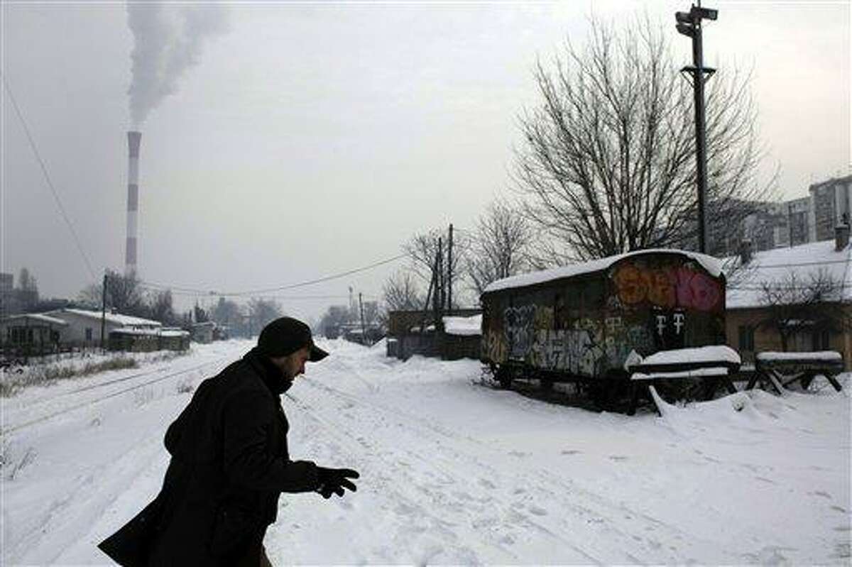 A man races across snow covered train tracks in Belgrade, Serbia, Thursday. Associated Press