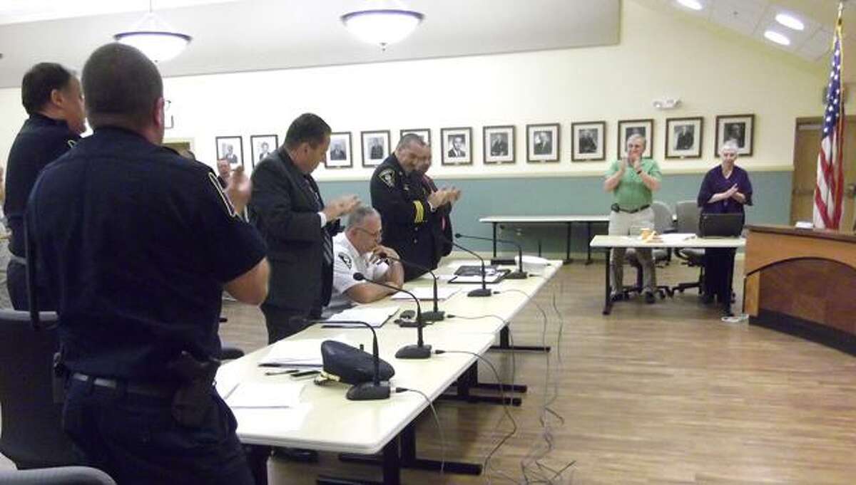 Torrington Fire Chief John Field, seated, receives a standing ovation following his Board of Safety meeting announcement he will retire July 8. (RICKY CAMPBELL / Register Citizen)