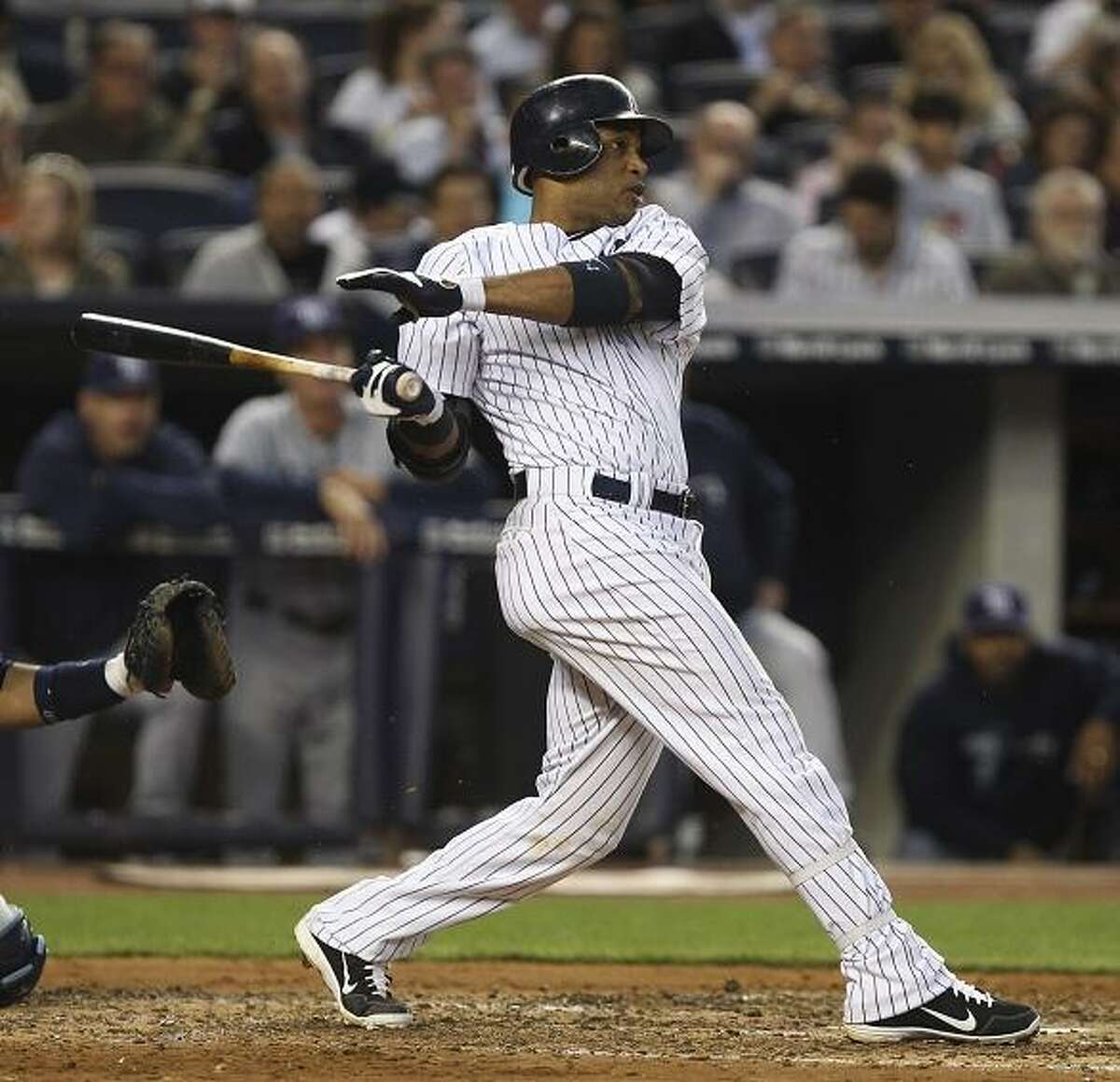 New York Yankees' Robinson Cano follows through on a solo home run during the fourth inning of a baseball game against the Tampa Bay Rays at Yankee Stadium in New York, Wednesday, June 6, 2012. (AP Photo/Seth Wenig)