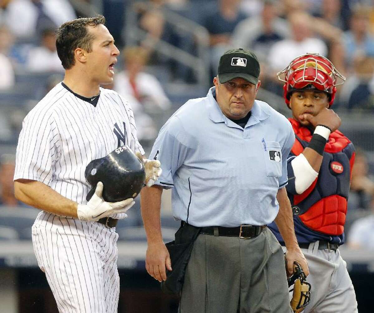 ASSOCIATED PRESS New York's Mark Teixeira, left, shouts at Cleveland Indians pitcher Fausto Carmona after Carmona hit him with a pitch as plate umpire Dale Scott (5) gets in between Teixeira and Indians catcher Carlos Santana, right, in the second inning of Friday's game at Yankee Stadium in New York.