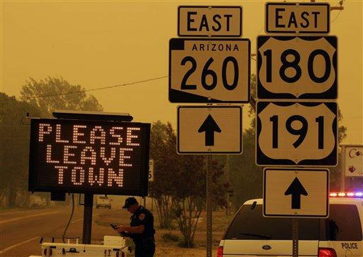 A sign asks for residents to evacuate as the Wallow Fire approaches in Springerville, Ariz., Wednesday, June 8, 2011. A raging forest fire in eastern Arizona has scorched an area the size of Phoenix, threatening thousands of residents and emptying towns as the flames raced toward New Mexico.(AP Photo/Marcio Jose Sanchez)