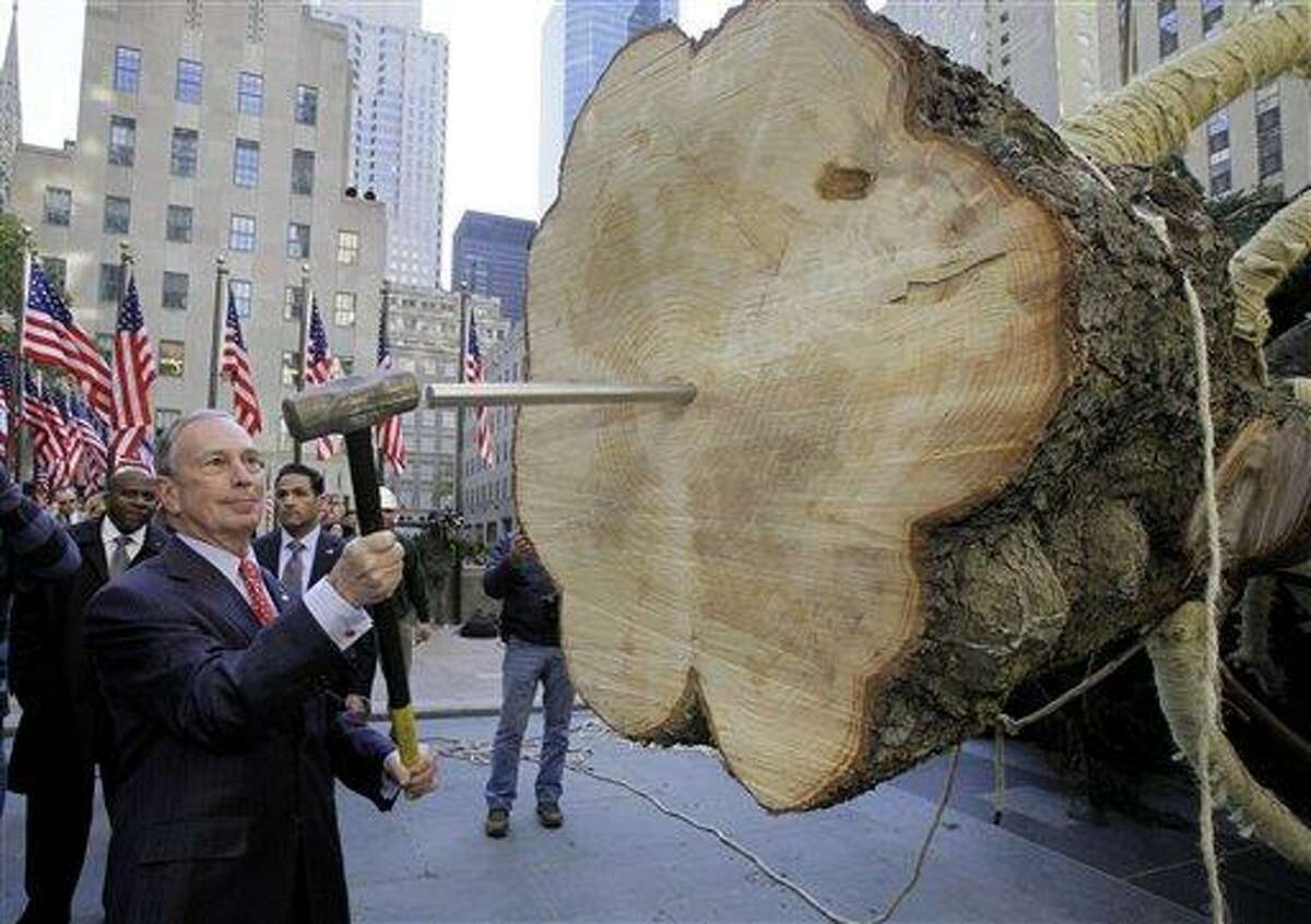 New York Mayor Michael Bloomberg takes his turn to drive the spike in the bottom of the annual Rockefeller Center Christmas tree, in New York, Friday, Nov. 11, 2011. The 74-foot Norway Spruce, from Mifflinville, Pa., is approximately 75 years old and is scheduled to be illuminated Nov. 30. (AP Photo/Richard Drew)