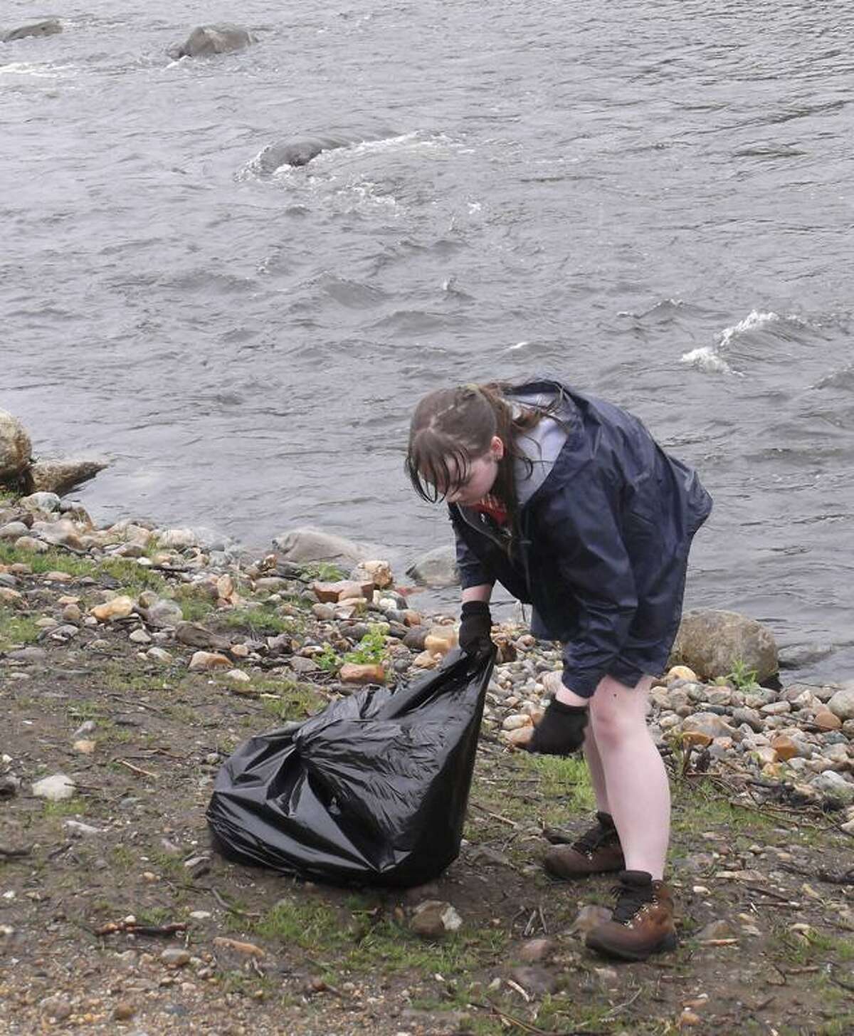 RICKY CAMPBELL/ Register Citizen Aimee Gregg, 15, walks along the Naugatuck River near Torrington's Sullivan Senior Center, picking up garbage and debris leftover from Hurricane Irene and careless citizens. Gregg, an FFA member from Barkhamsted, joined other groups Saturday during the 6th Annual Naugatuck River Clean Up effort from Torrington's north end to Campville.