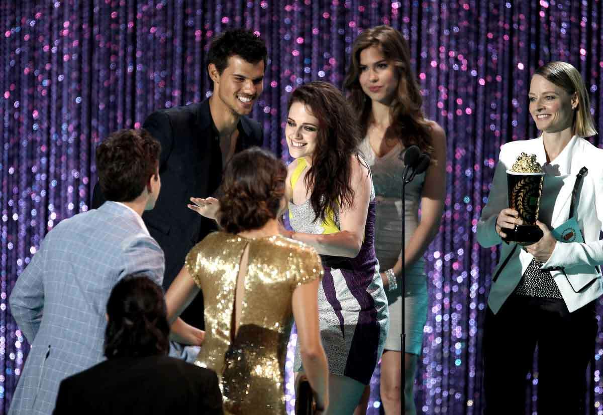 The cast of "The Twilight Saga: Breaking Dawn, Part 1" is seen on stage as they accept the award for movie of the year from presenter Jodie Foster, right, at the MTV Movie Awards on Sunday, June 3, 2012, in Los Angeles. (Photo by Matt Sayles/Invision/AP)